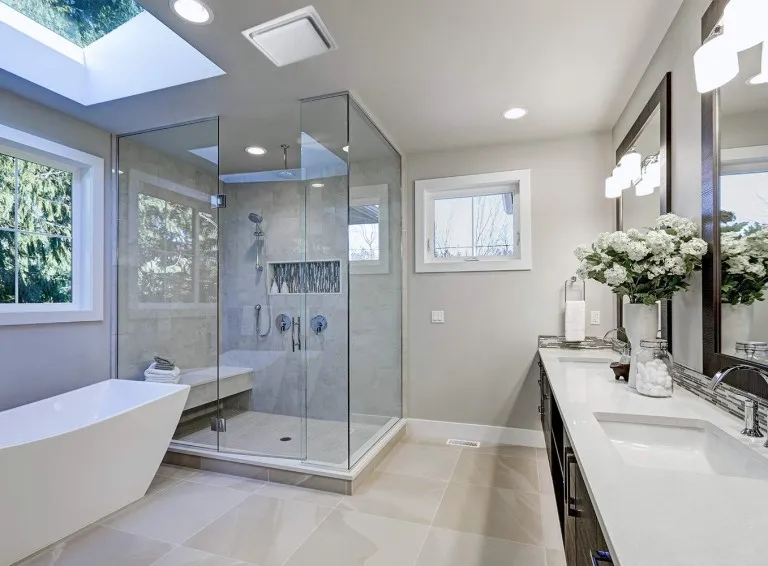Modern bathroom with a ceiling exhaust vent above the glass shower