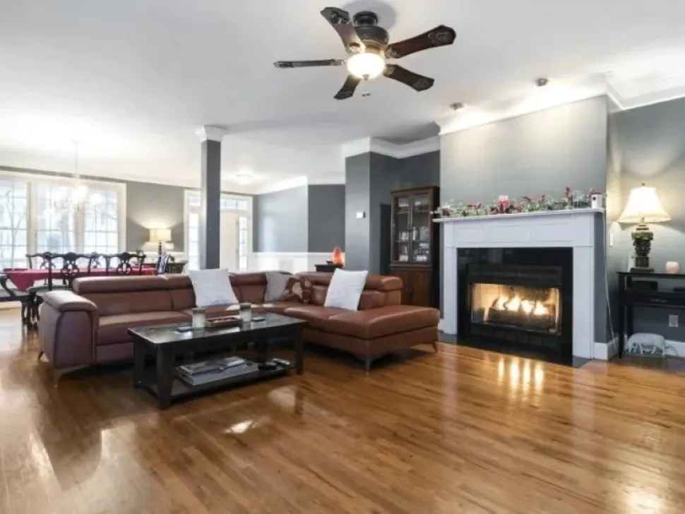 Ceiling fan with a light in a living room with a fireplace