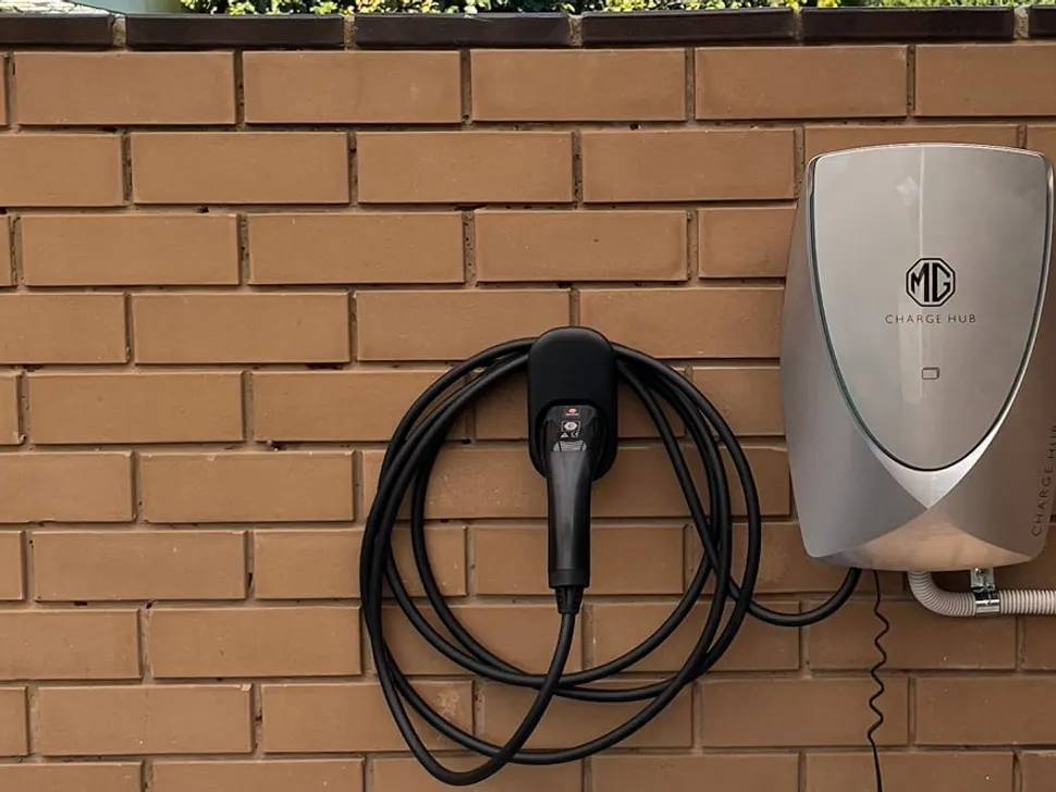 Wall-mounted home EV charger with its cable on an exterior wall