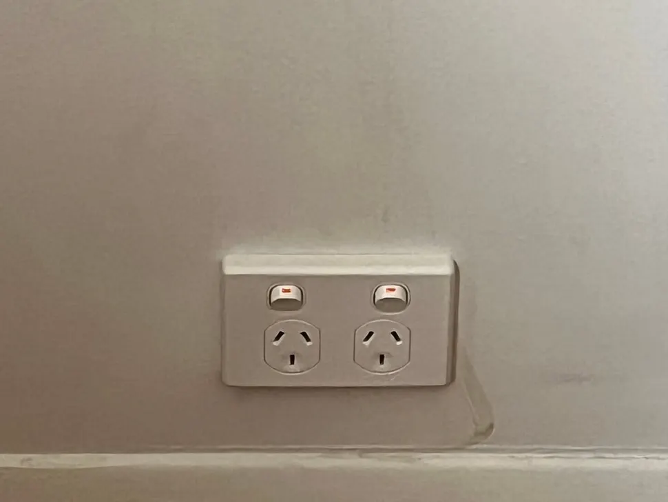 New double power point on a white wall above the skirting board