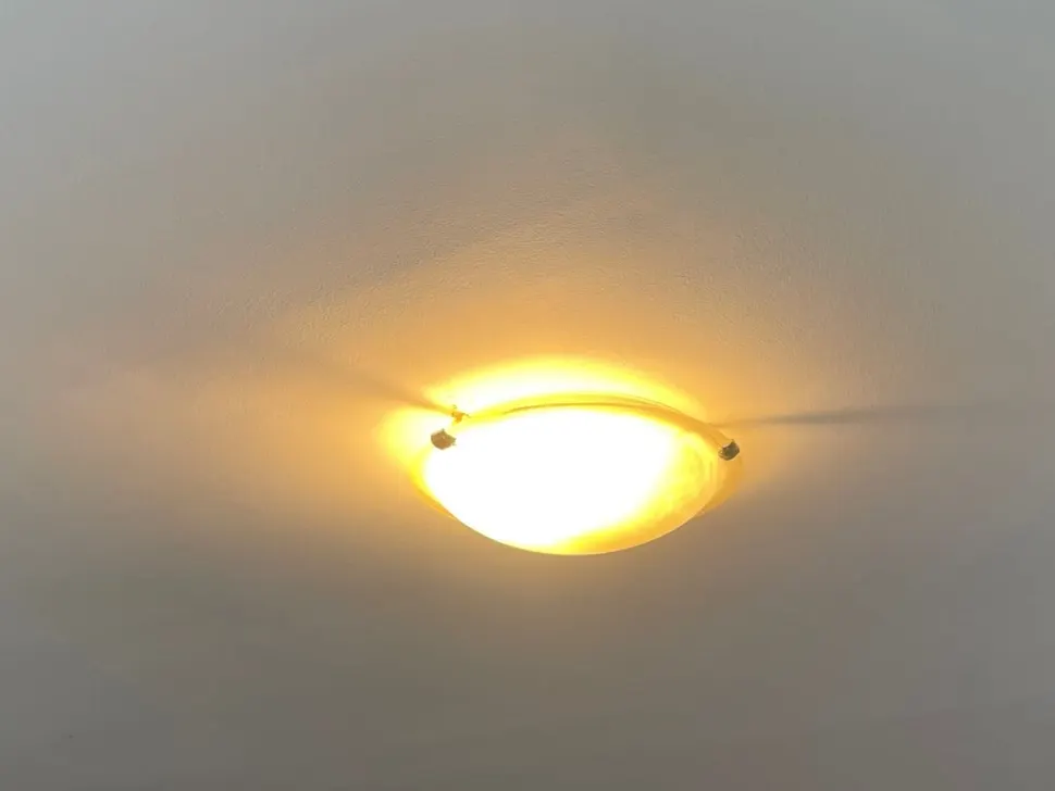 Lit ceiling light fitting in a plain ceiling