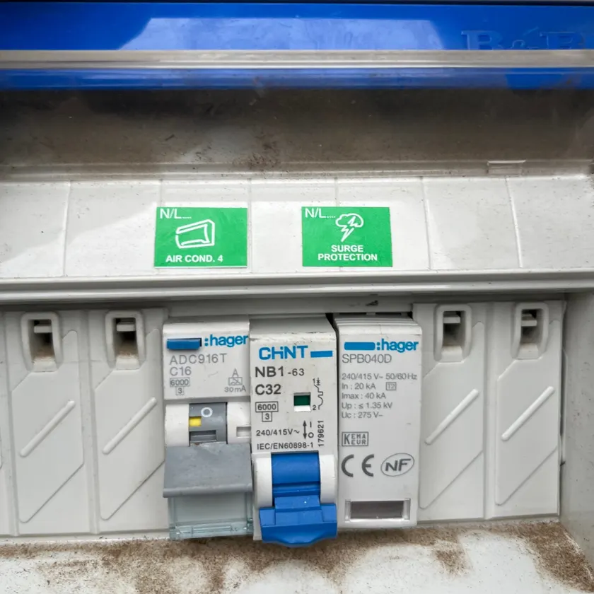 Switchboard with a breaker labelled air conditioner on its own RCBO, next to a surge protection device labelled surge protection