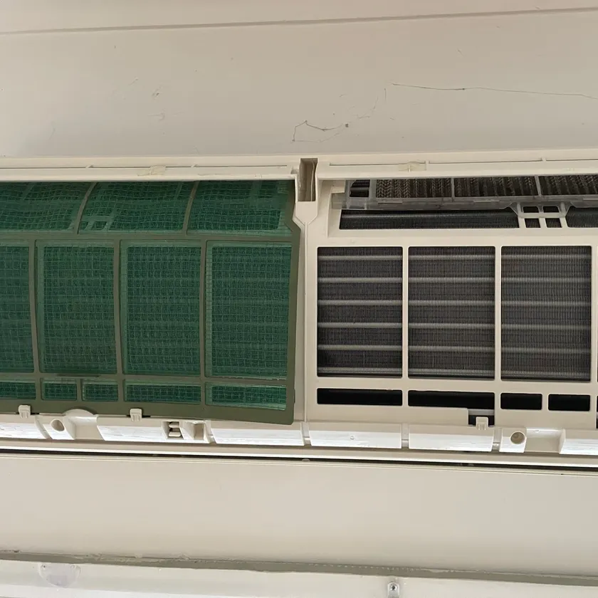 Split system indoor unit opened during a service, one filter cleaned and the other still clogged with dust