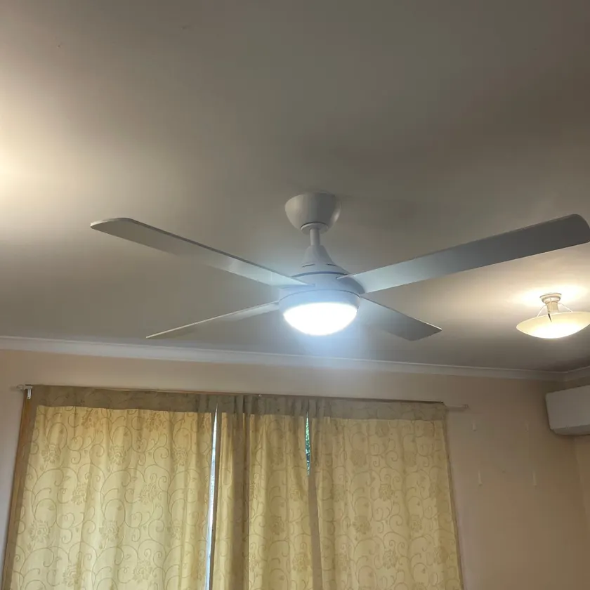 White four-blade ceiling fan with a light in a lounge room