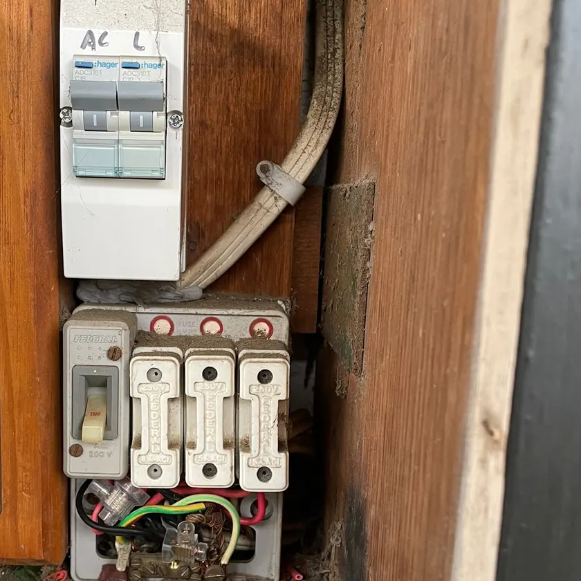 Old dusty switchboard with ceramic fuses and one older circuit breaker