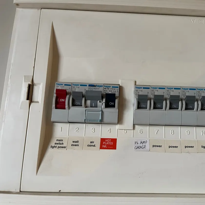 Older switchboard with individual circuit breakers and a single safety switch covering several circuits