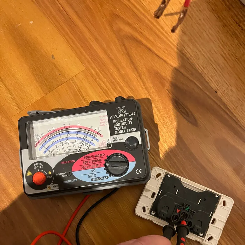 Insulation tester probes on the terminals of a power point