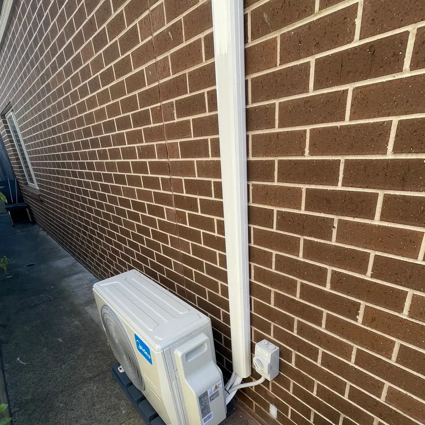 Outdoor unit with conduit and isolator in a side passage