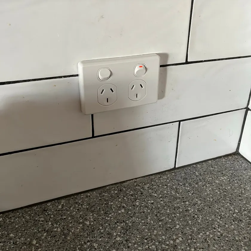 Clean double power point on a white tiled splashback