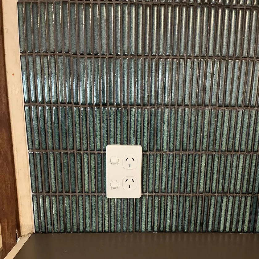 Finished double power point on a teal mosaic splashback, wall plate and tiles only