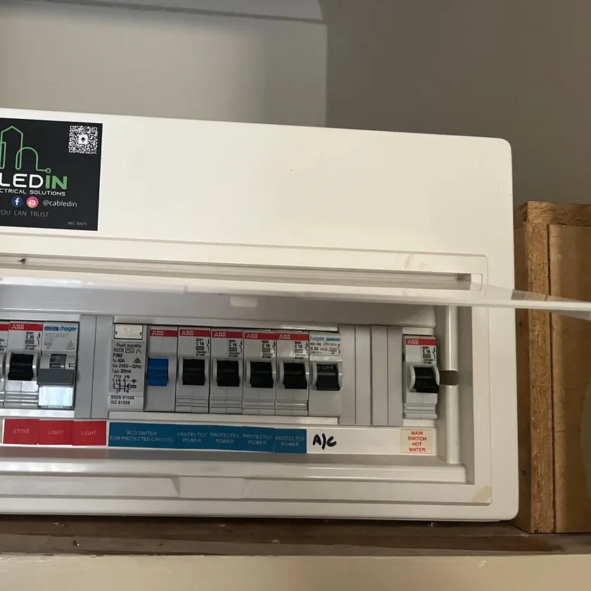 Switchboard with the lid lifted, labelled circuit breakers and a CabledIN sticker