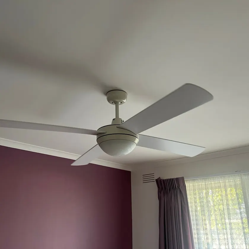 White ceiling fan with a light on a bedroom ceiling