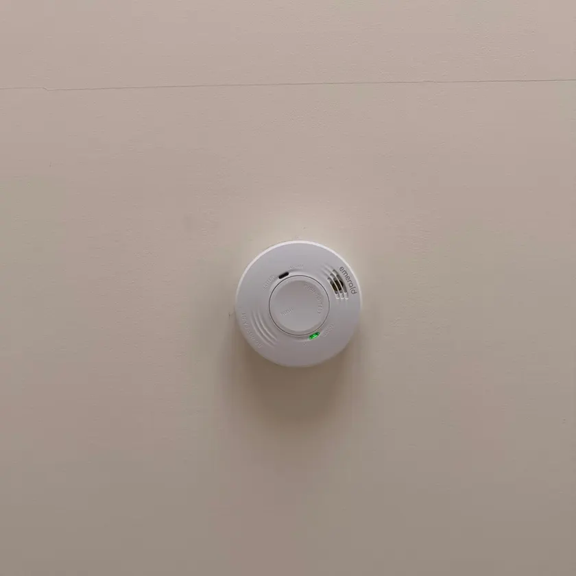 White smoke alarm fitted to a ceiling