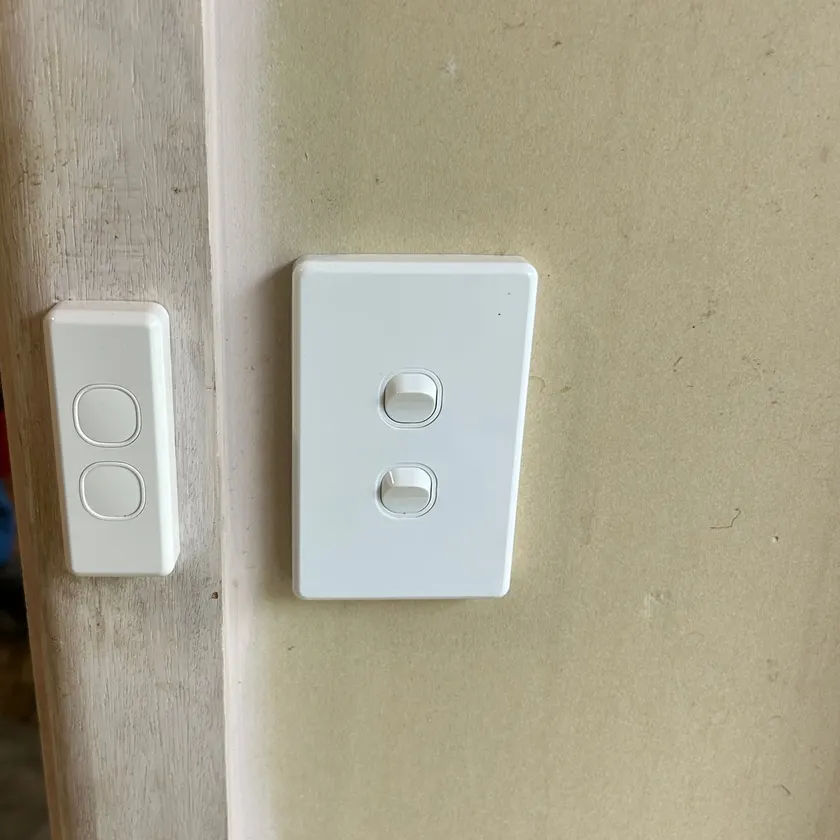 New white light switches mounted on a door architrave