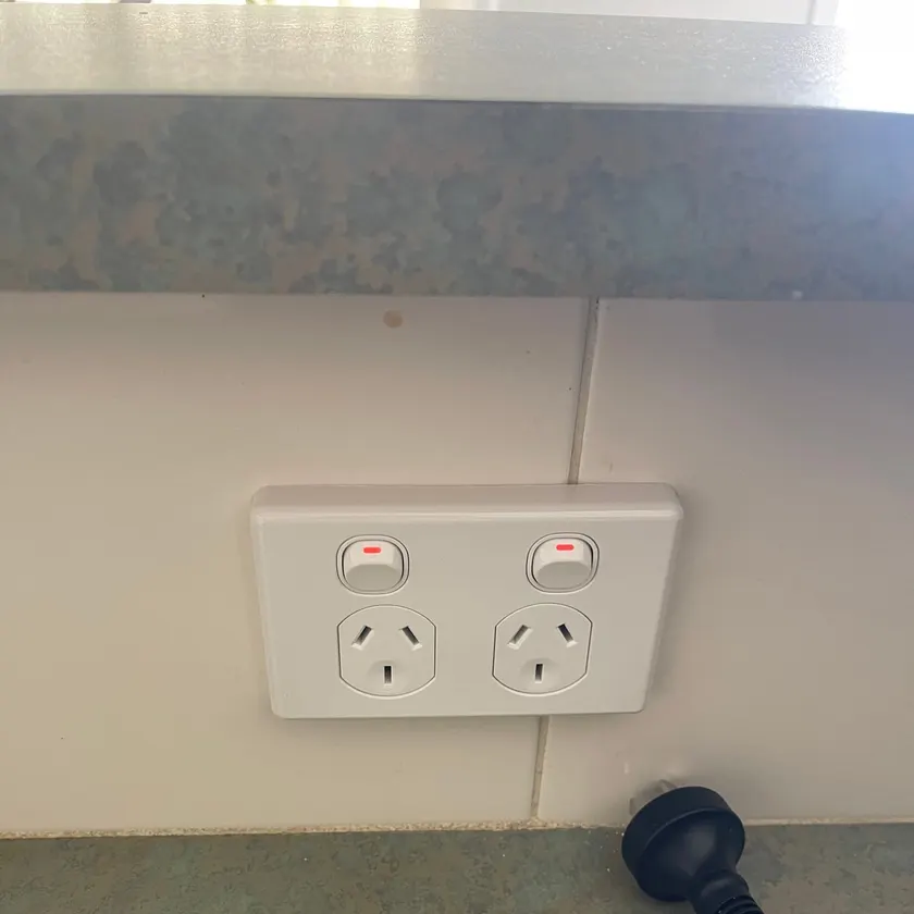 White double power point on a wall above a benchtop