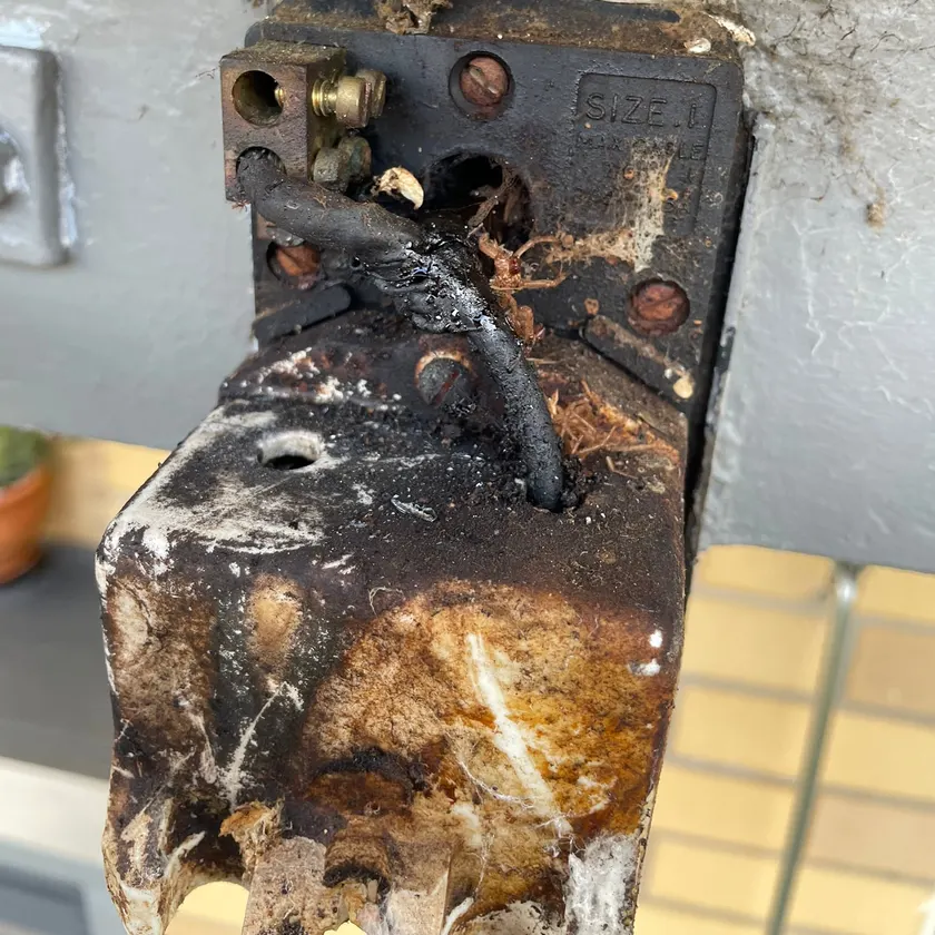 Badly burnt and melted old service fuse on a fascia