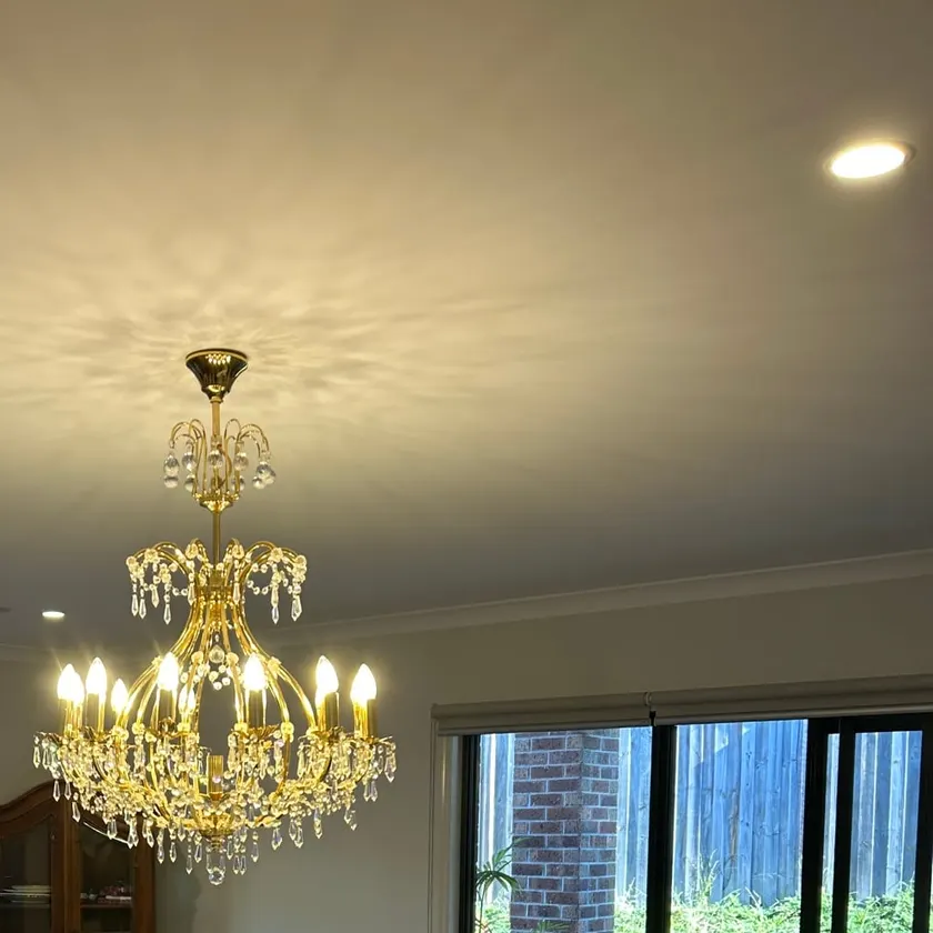 Chandelier-style pendant light hanging from the ceiling of a lounge and dining room