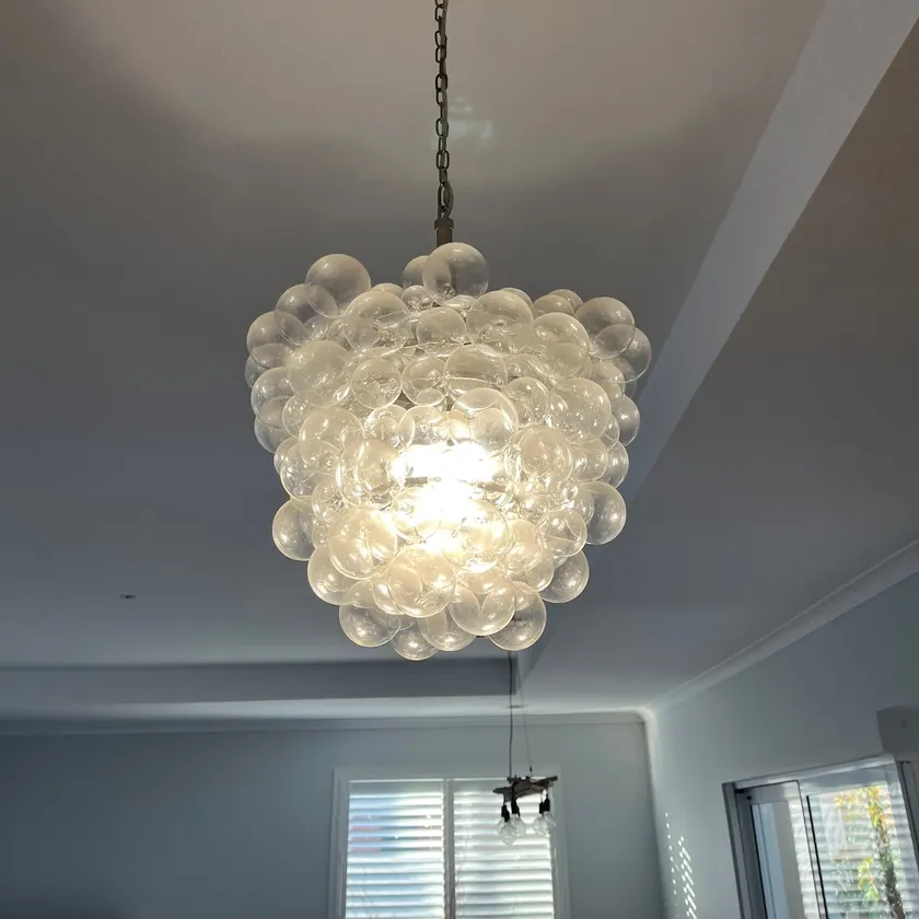 Glass pendant light with a bubble-pattern shade hanging from a white ceiling