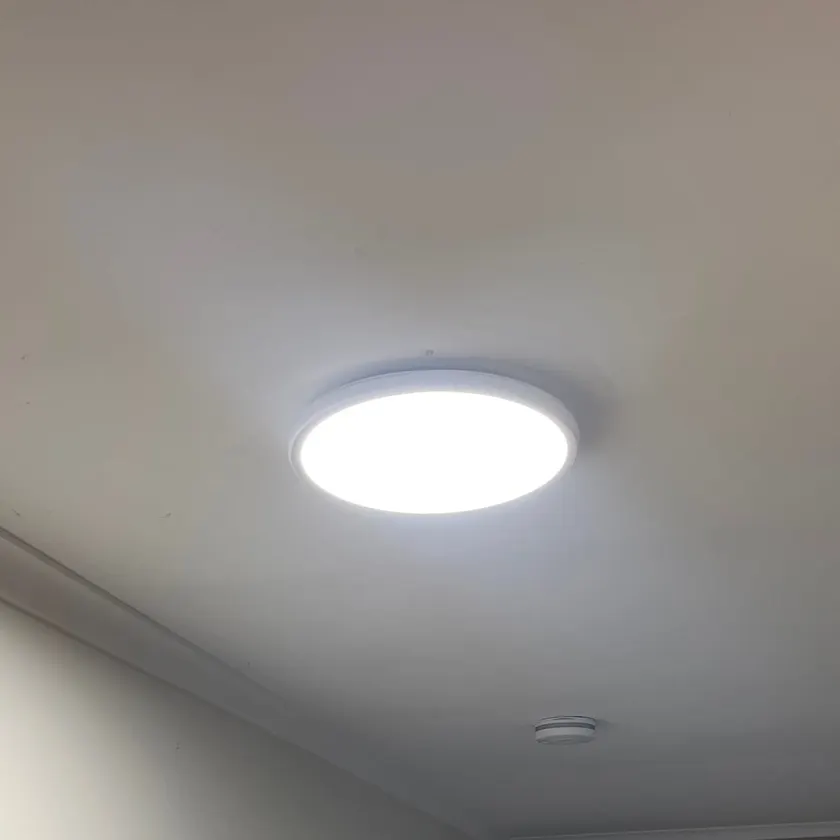 Round flat LED ceiling panel in a hallway
