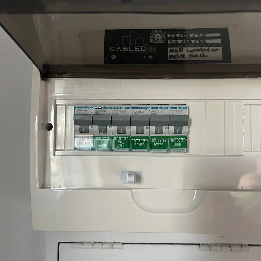 Close-up of safety switches labelled hot water, wall oven, power and light in a new switchboard