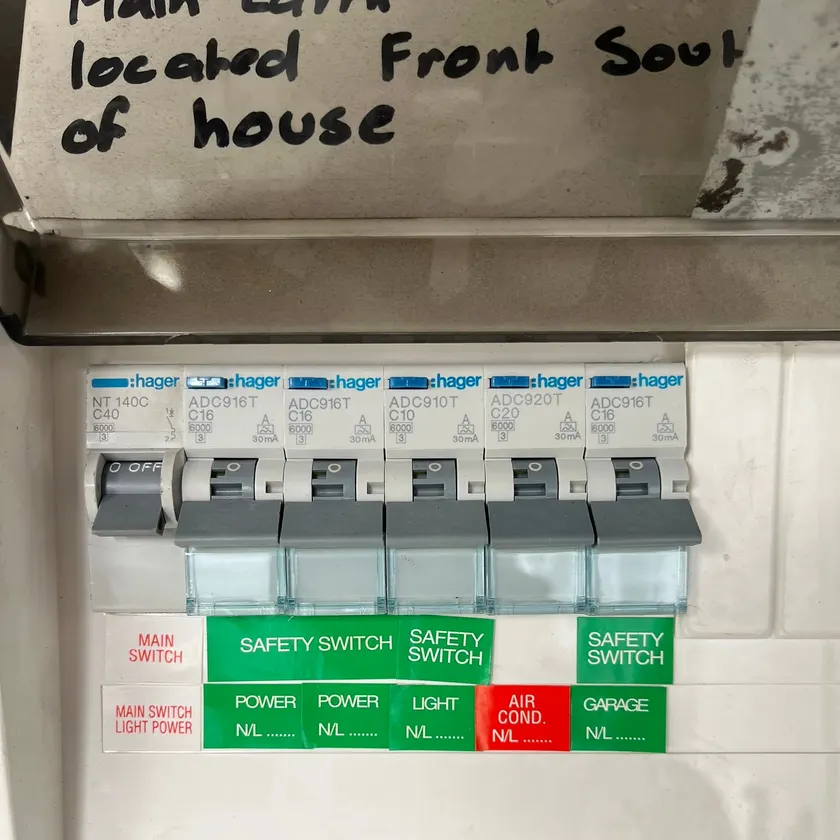 Row of combined safety switches under green safety switch labels in a switchboard