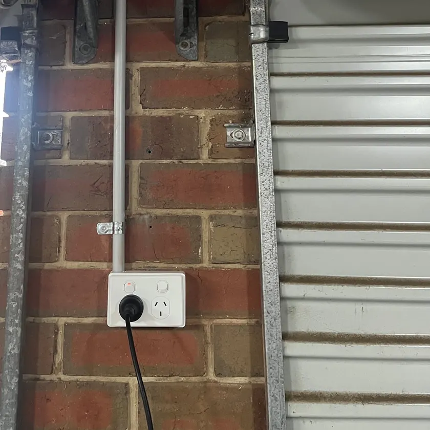 Conduit down a brick garage pillar to a double power point beside a roller door